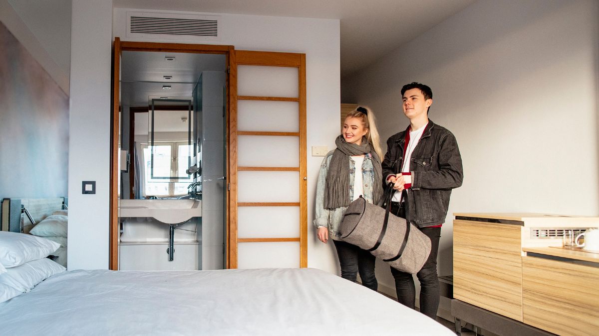 Male and female couple smiling in hotel room