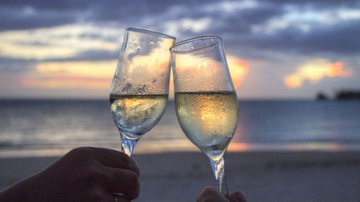 Champagne cheers on the beach at sunset
