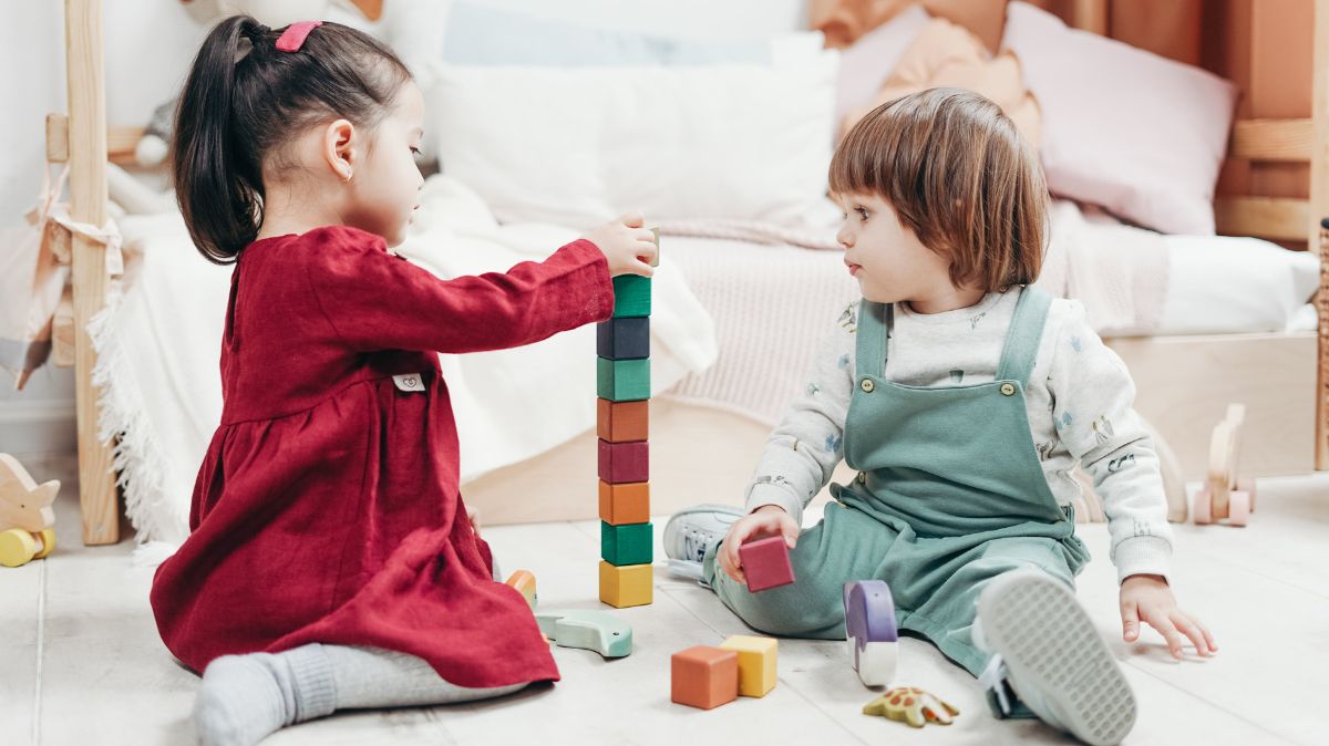 Two children playing with colourful building blocks
