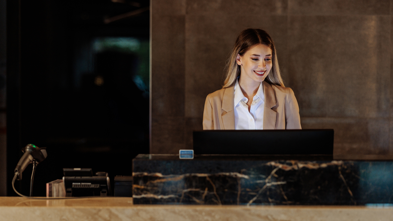 Portrait of young hotel receptionist behind counter